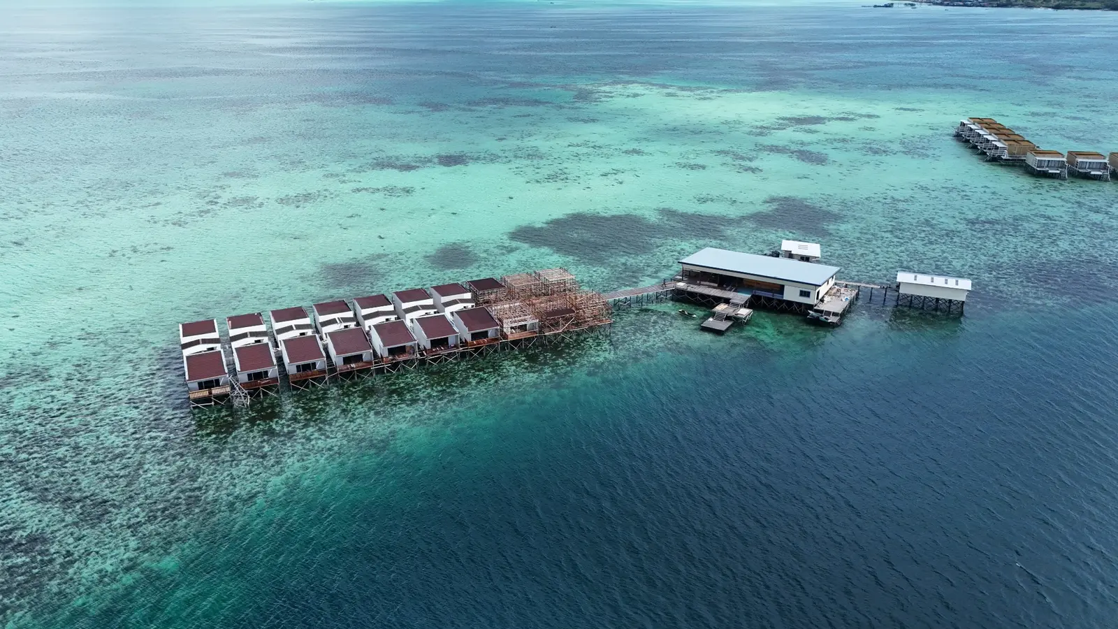 Fotografi udara jajaran vila resort atas air di Semporna
